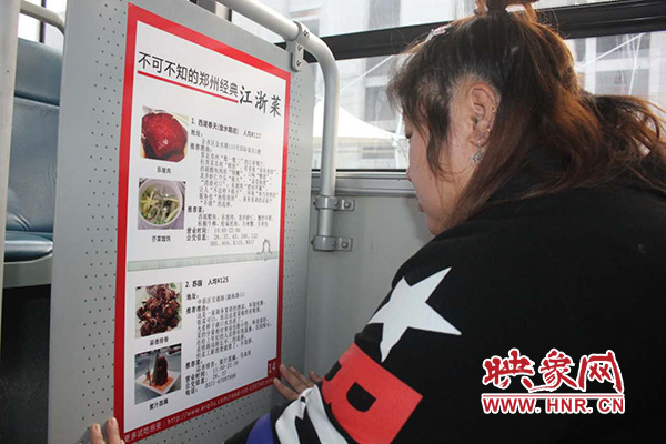 車長(zhǎng)在車廂內(nèi)張貼鄭州美食宣傳頁(yè)