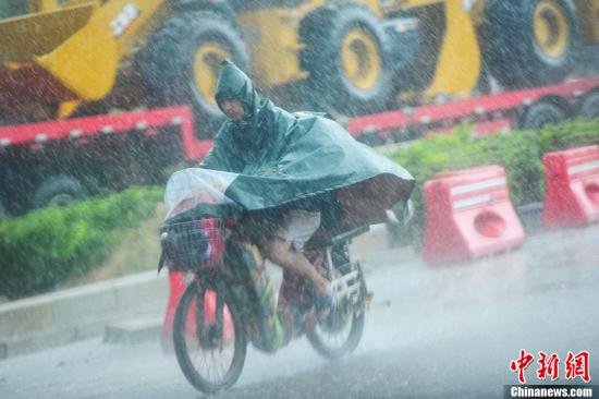 圖為南寧市民冒雨出行。中新社發(fā) 馮抒敏 攝