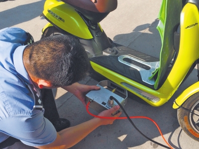 民警手持打碼機(jī)正對電動(dòng)車車架刻編碼