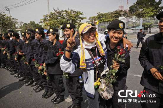 2013年12月03日,曼谷總理府與曼谷警署允許反政府示威民眾進(jìn)入,雙方進(jìn)入暫時“停戰(zhàn)”狀態(tài)迎接泰王生日。曼谷警察總署,女警們手持鮮花送給反政府示威民眾。圖片來源:Manish Swarup/東方IC