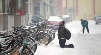 小伙子跪在樓前，一直抬頭看著樓上。 孫立國(guó)/攝